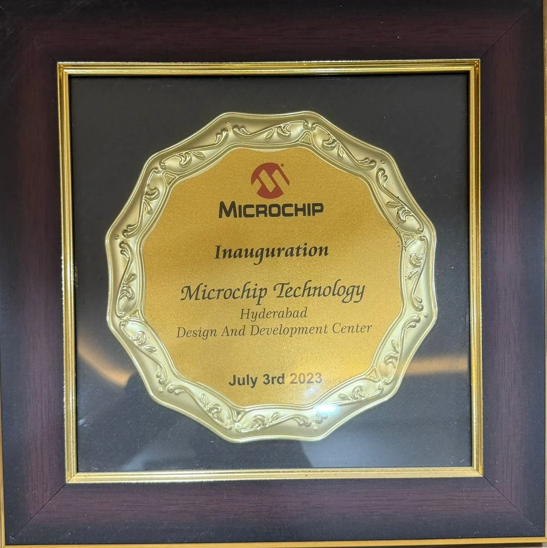 Framed gold scalloped plaque under the Microchip logo reading Inauguration, Microchip Technology, Hyderabad Design And Development Center, July 3rd 2023.