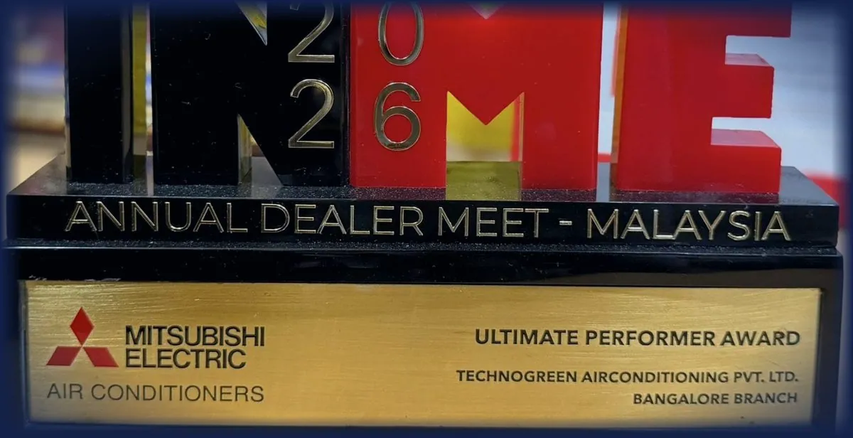 Trophy spelling INME 2026 above the line Annual Dealer Meet — Malaysia, over a brass plate reading Mitsubishi Electric Air Conditioners, Ultimate Performer Award, Technogreen Airconditioning Pvt. Ltd., Bangalore Branch.