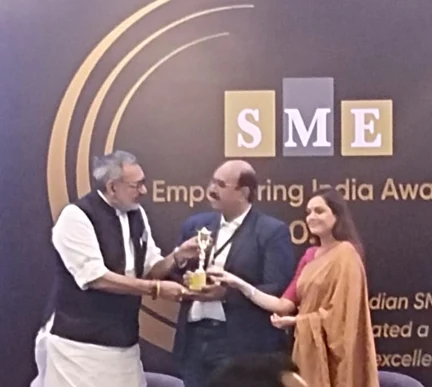 Dattatreya Lakshmi Narasimha being handed a gold trophy on stage in front of a backdrop reading SME Empowering India Awards.