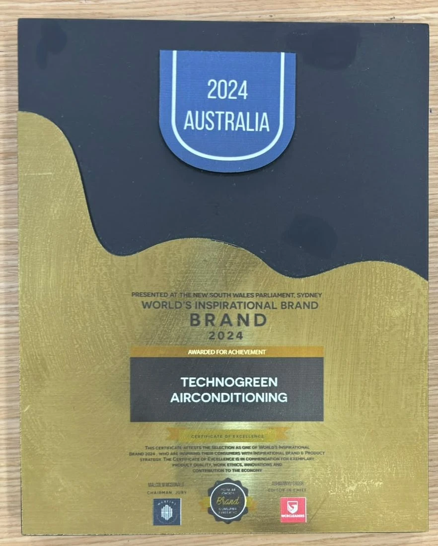 Black and gold plaque topped with a badge reading 2024 Australia, lettered Presented at the New South Wales Parliament, Sydney, World's Inspirational Brand 2024, awarded for achievement to Technogreen Airconditioning, with a Certificate of Excellence citation for exemplary product quality, work ethics, innovations and contribution to the economy.