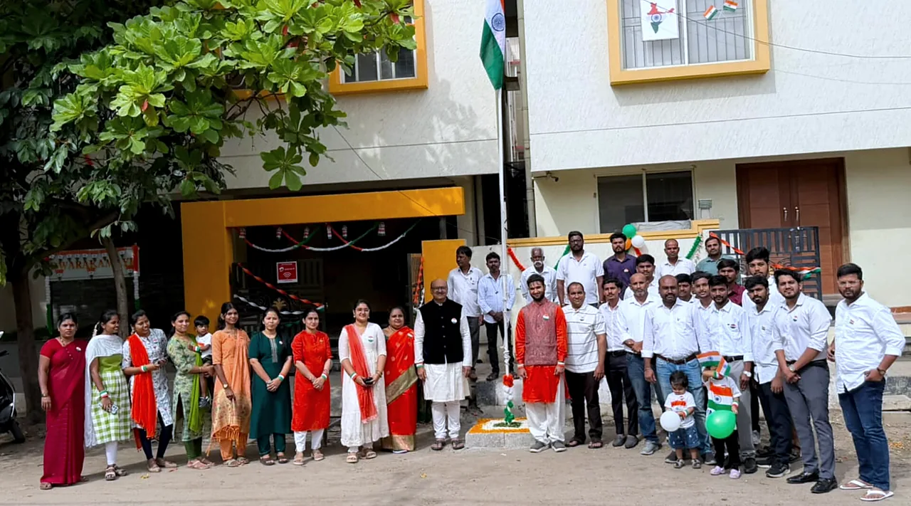 Office staff and site crew standing together at the flag pole outside the office after the hoisting.