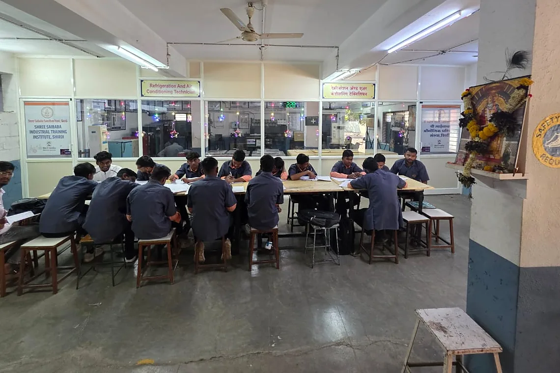 Trainees at a long bench in a refrigeration and air conditioning training room.