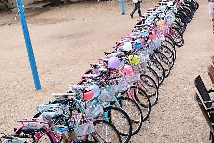 A long row of new bicycles parked on a school ground.