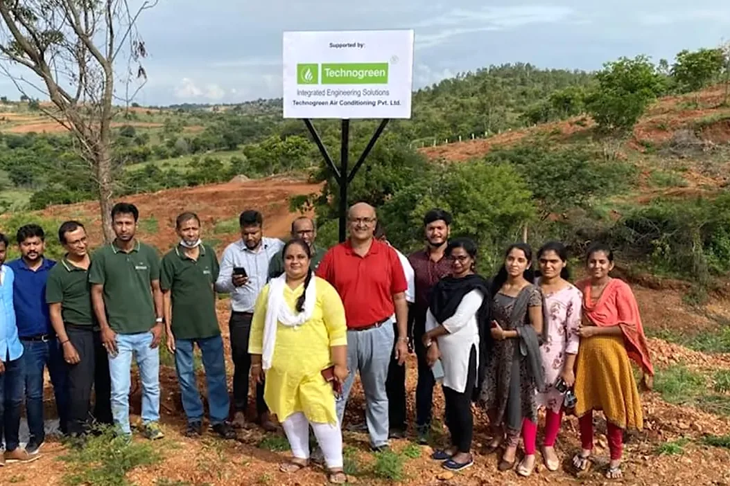 A group standing together on cleared hillside at the planting ground.