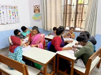 Children at work around low desks in a bright, decorated classroom at the Sakya centre.