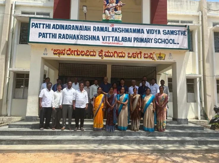 The team lined up with school staff outside a primary school.