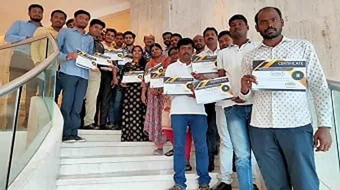 A group holding certificates at the close of a training programme.