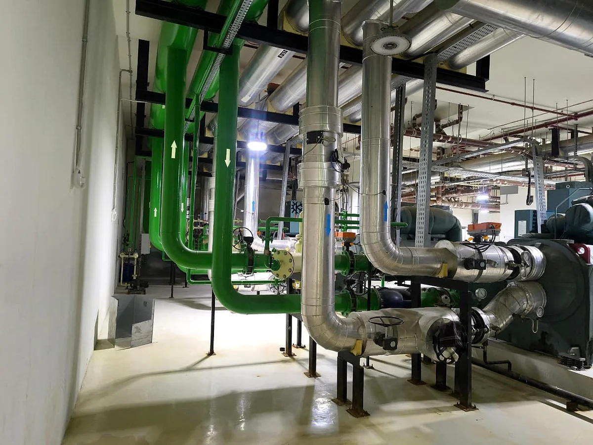 Pump sets on housekeeping pads, with green pipework and strainers running between them.