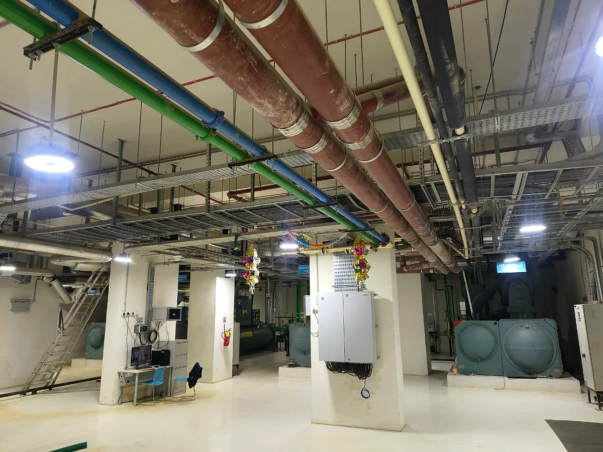Overhead services — chilled water, condenser water and cable containment stacked through the soffit.